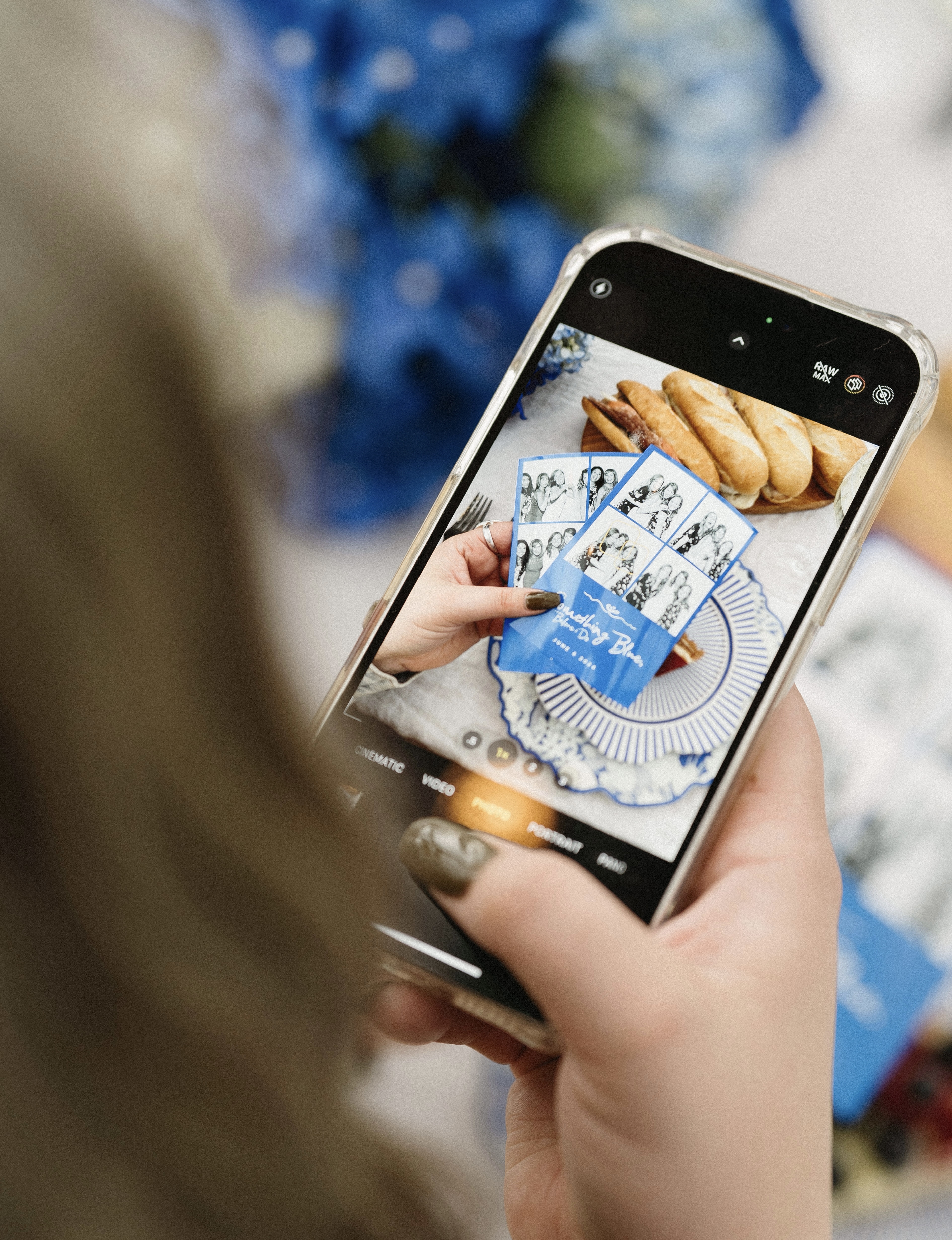 A guest photographing blue photo strips on their phone