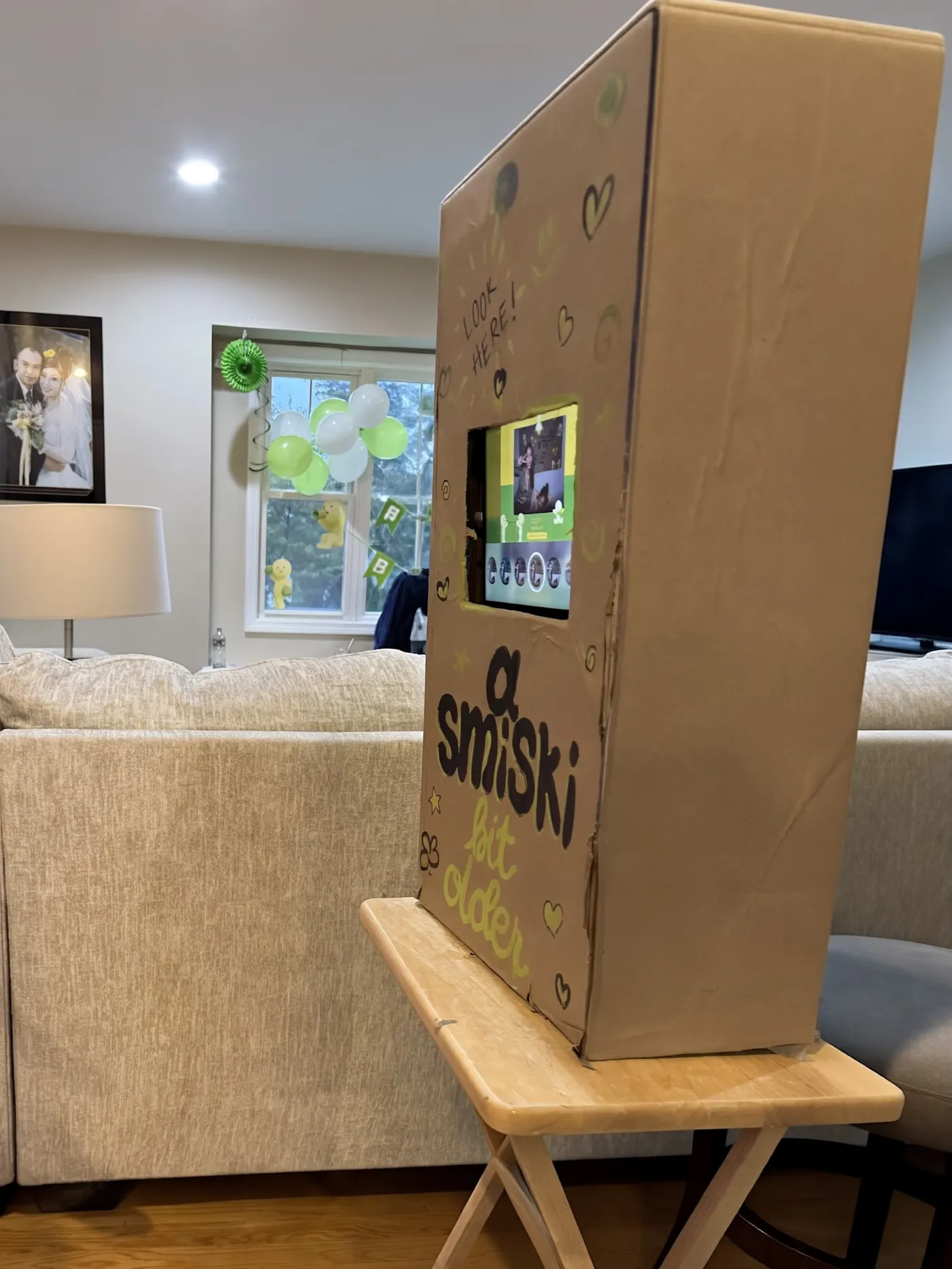 The decorated cardboard photo booth on a folding table at a birthday party