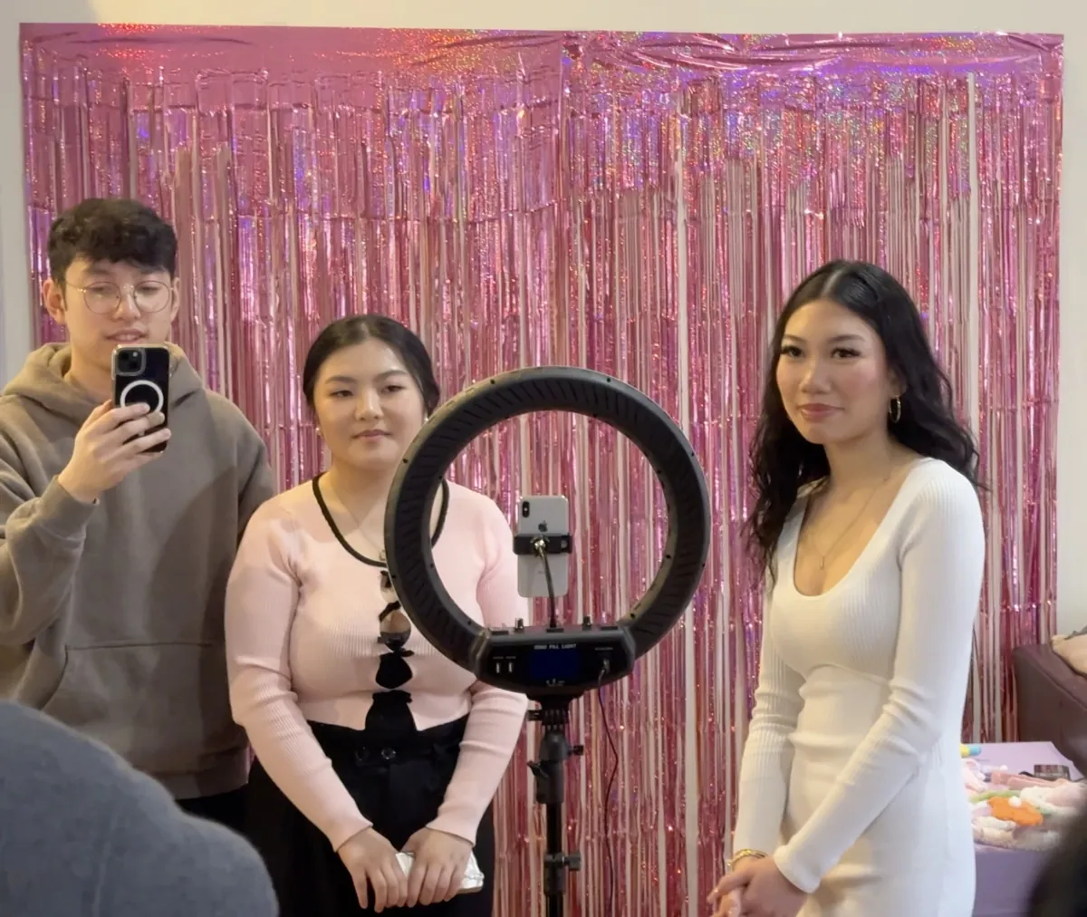 An early setup with a ring light in front of a pink tinsel backdrop
