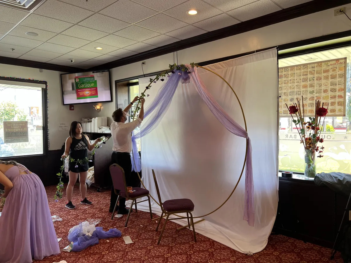 Setting up a floral arch and backdrop before an event